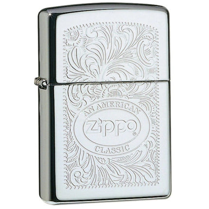 A front view of a Zippo lighter with a High Polish Chrome finish, featuring an intricate engraved filigree pattern surrounding a central oval logo that reads 'An American Zippo Classic'.