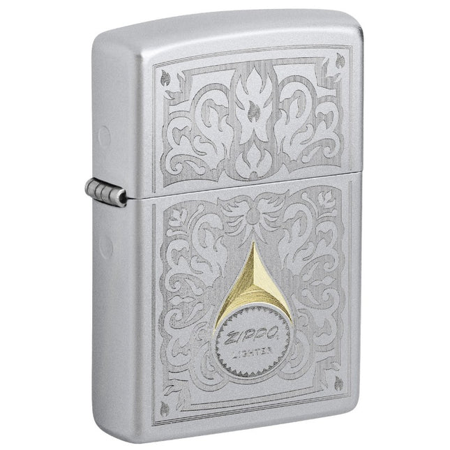 Front view of a Satin Chrome Zippo lighter featuring an intricate engraved filigree pattern. The Auto Two-Tone design exposes golden brass tones for the vintage Zippo logo and the floral scrollwork.'
